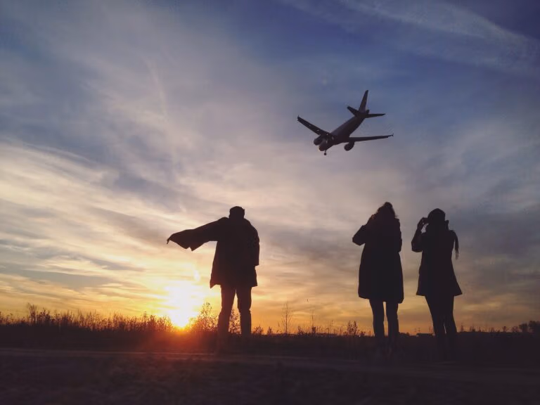 Airplane flying with 3 people watching